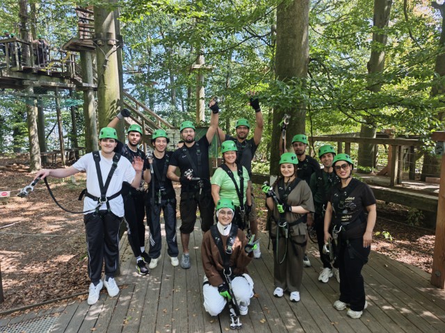Gruppenfoto in Kletterausrüstung mit grünen Helmen im Kletterwald in Wetter